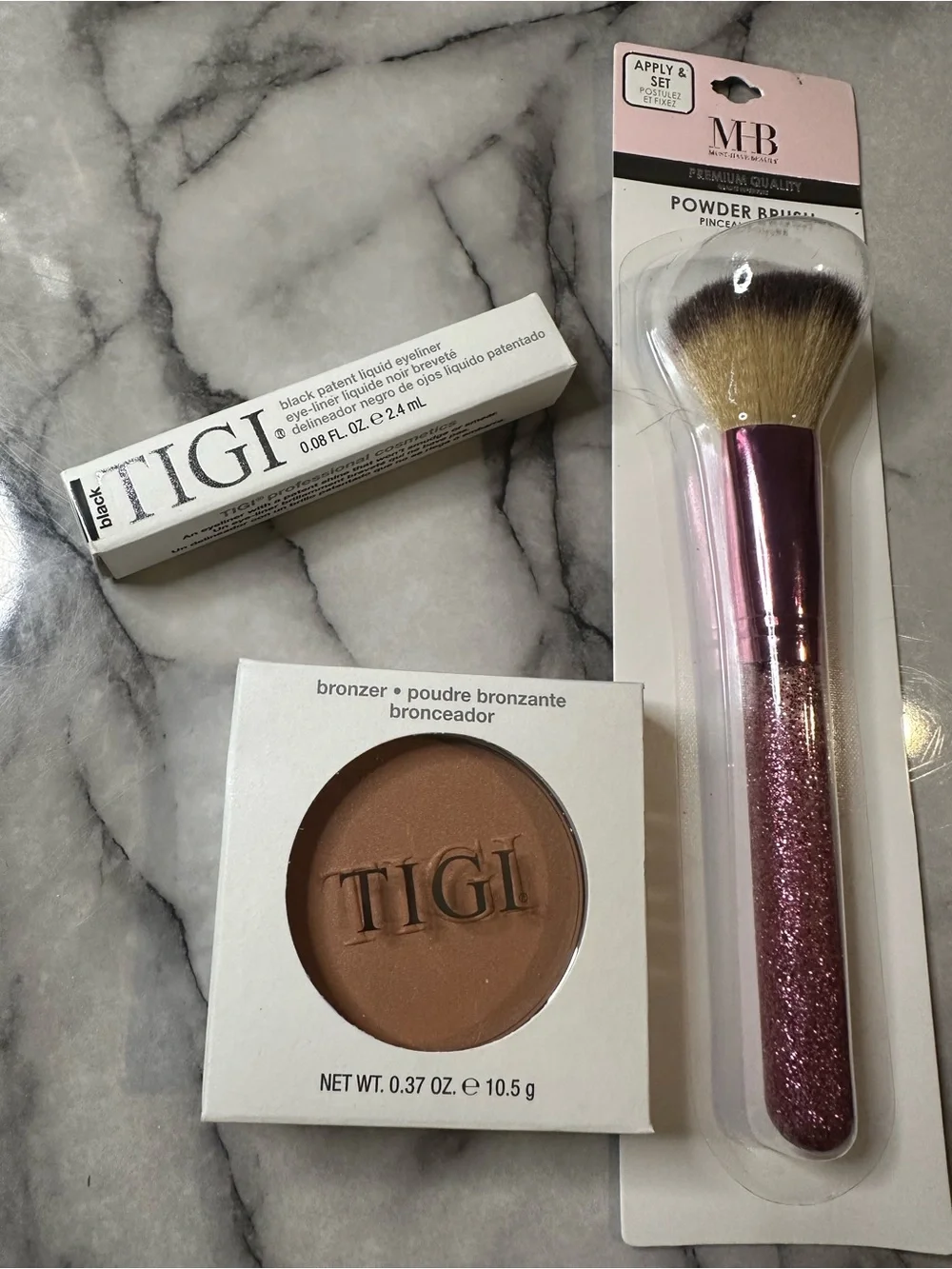 TIGI Bronzer Compact, liquid eyeliner, and blush brush.